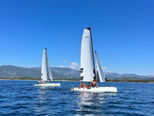 Deux catamarans de l'école naviguant sous un ciel bleu dans la baie de Porto-Vecchio