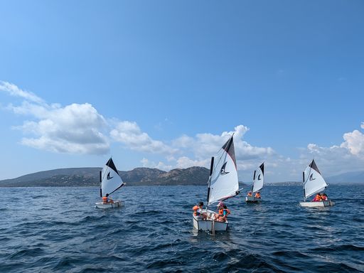 Enfants naviguant en optimist dans la baie de Porto-Vecchio pendant un stage d'été