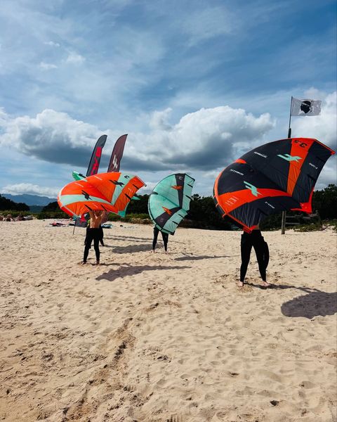 Élèves apprenant à manier leur aile de wingfoil sur la plage de Cala Rossa